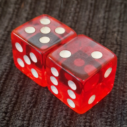 A pair of six-sided dice, red with white pips on a black background. The faces have nonstandard pip counts, suggesting incompetence or ill intent.